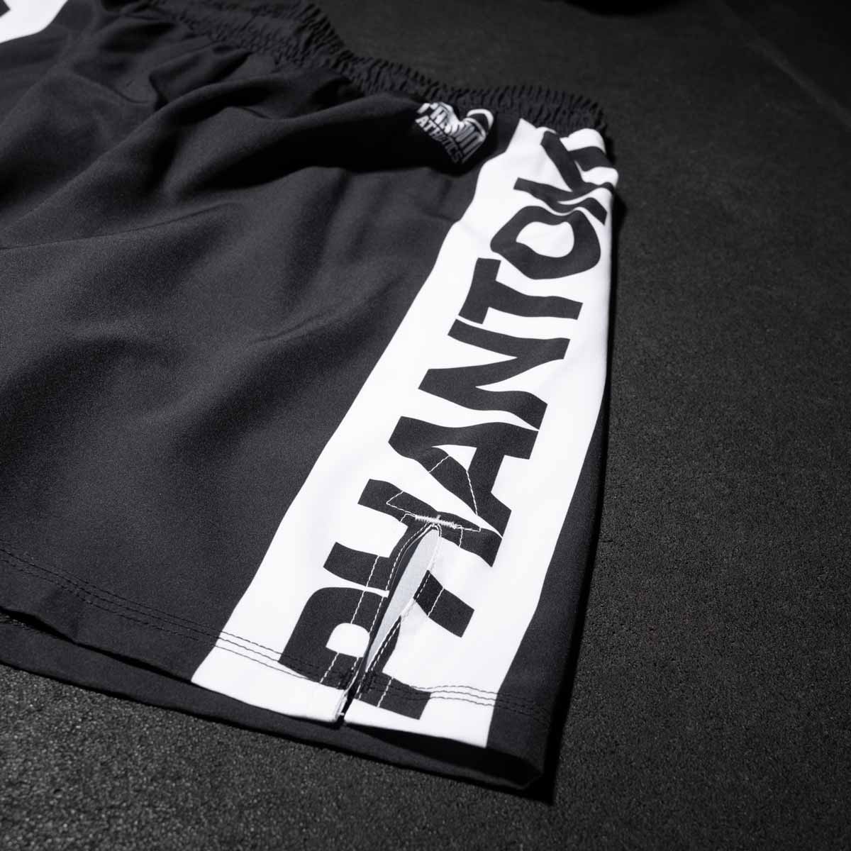 Die Phantom MMA Fightshorts APEX in Schwarz am Gymboden mit seitlichem Schlitz und aus super elastischem Material für maximale Bewegungsfreiheit.