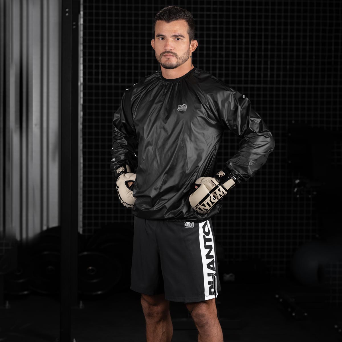 MMA Fighter im Gym mit der Phantom Apex MMA Fightshorts in Schwarz und der Phantom Sauna Suit Trainingsjacke.