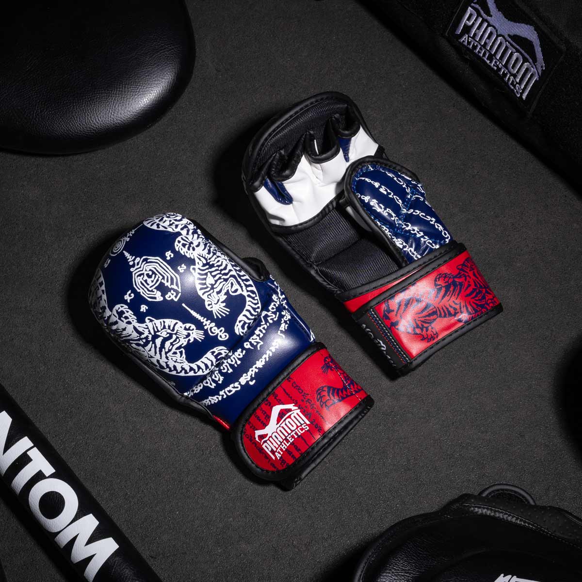 Phantom Muay Thai Handschuhe für Thaiboxen und MMA Sparring, Wettkampf und Training. Im traditionellen Sak Yant Design und der Farbe Blau/Rot.