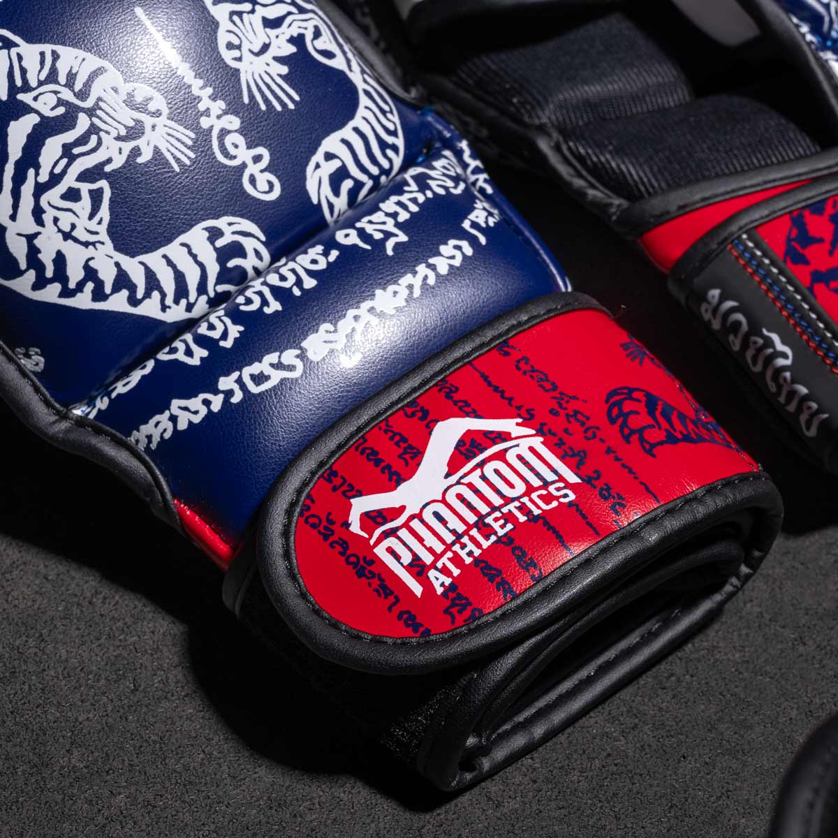 Phantom Muay Thai Handschuhe für Thaiboxen und MMA Sparring, Wettkampf und Training. Im traditionellen Sak Yant Design und der Farbe Blau/Rot.