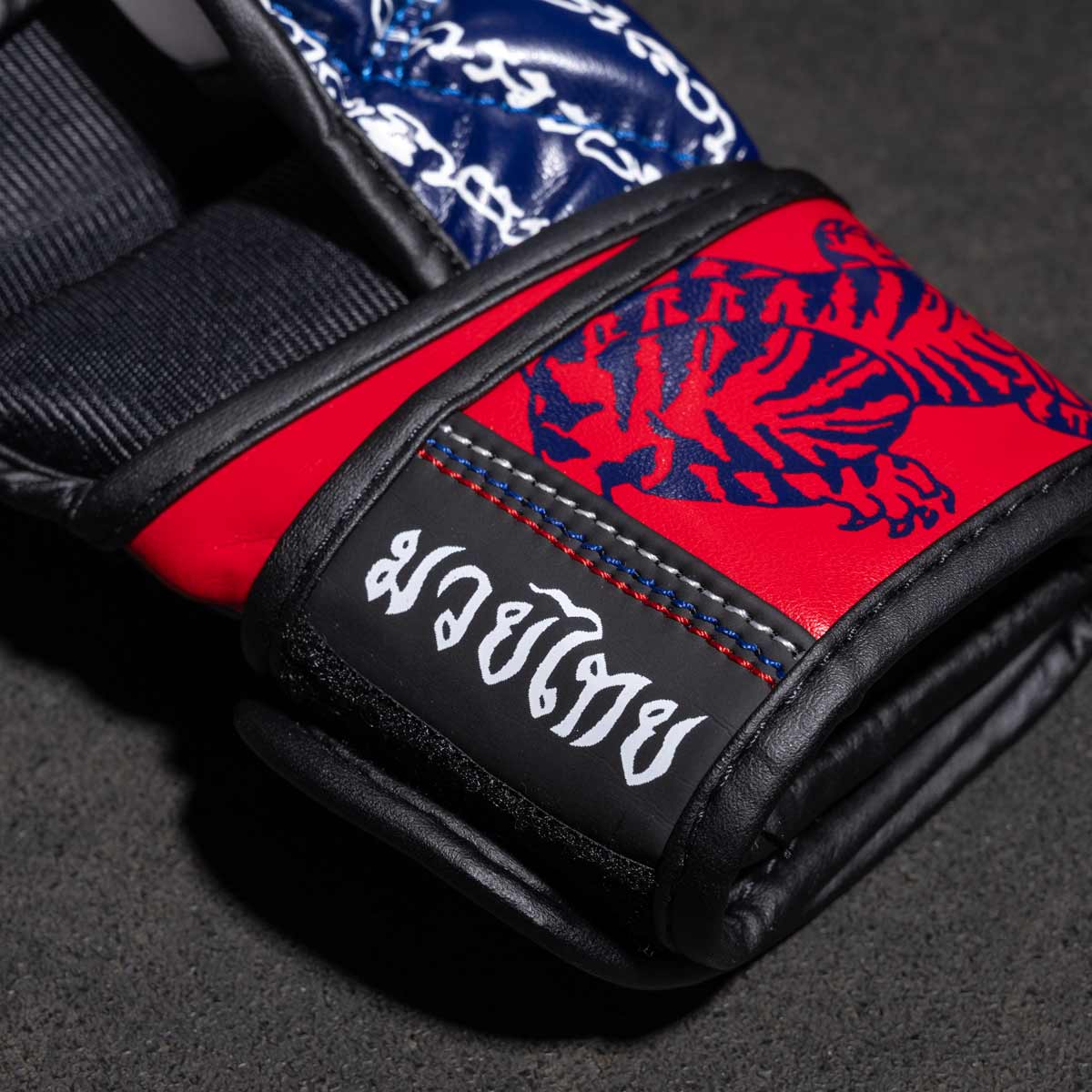 Phantom Muay Thai Handschuhe für Thaiboxen und MMA Sparring, Wettkampf und Training. Im traditionellen Sak Yant Design und der Farbe Blau/Rot.