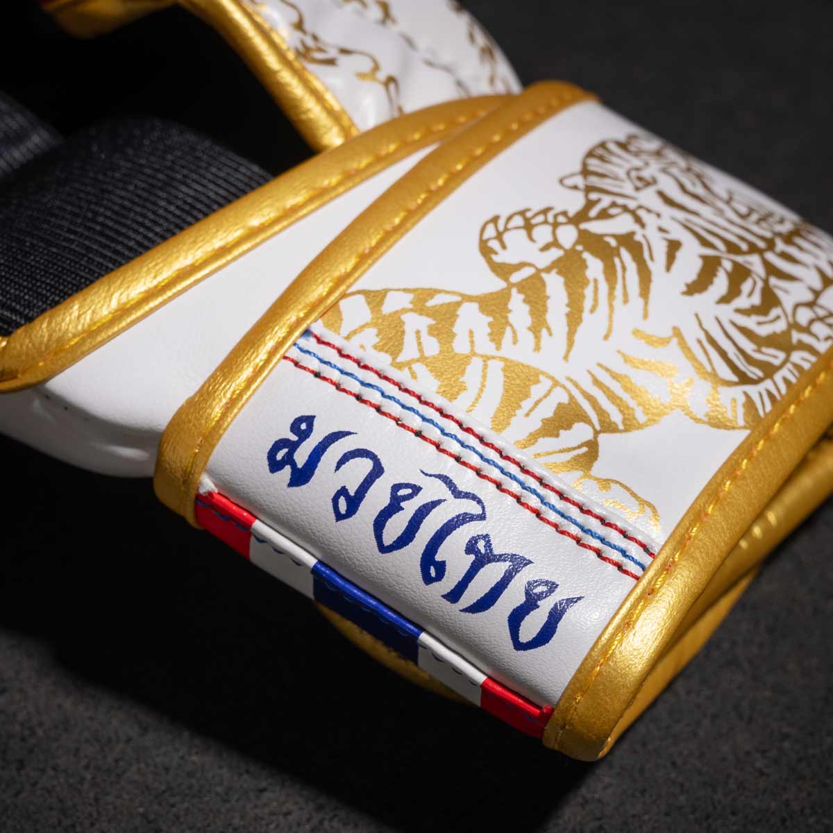 Phantom Muay Thai Handschuhe für Thaiboxen und MMA Sparring, Wettkampf und Training. Im traditionellen Sak Yant Design und der Farbe Weiß/Gold.