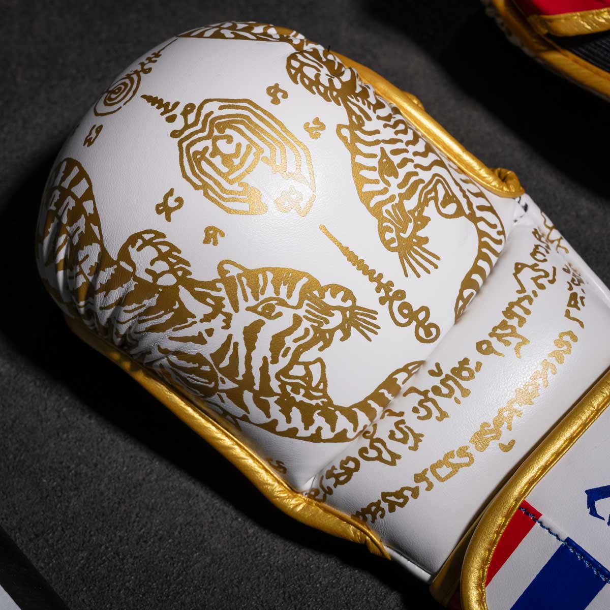 Phantom Muay Thai Handschuhe für Thaiboxen und MMA Sparring, Wettkampf und Training. Im traditionellen Sak Yant Design und der Farbe Weiß/Gold.