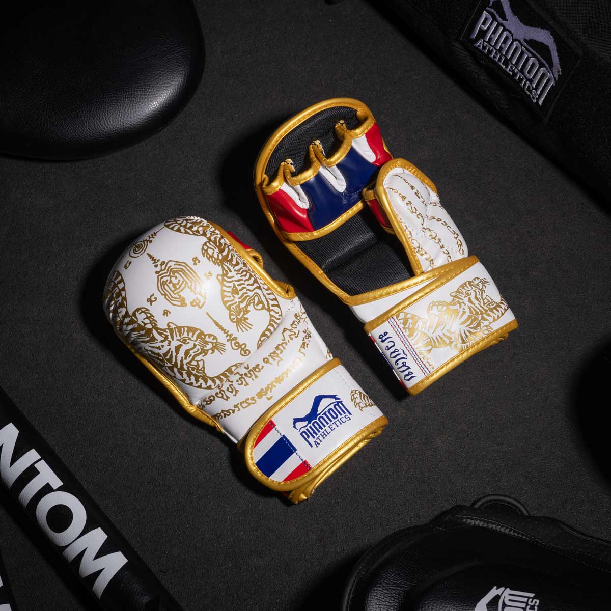 Phantom Muay Thai Handschuhe für Thaiboxen und MMA Sparring, Wettkampf und Training. Im traditionellen Sak Yant Design und der Farbe Weiß/Gold.