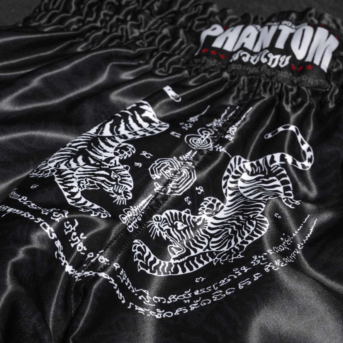 Die Phantom Muay Thai Shorts SAK YANT in schwarz. Oldschool Satin Stoff mit traditionellem Tiger Design verleiht dir original Thailand Feeling. In gewohnter Phantom Athletics Qualität. Ideal für dein Thaibox Training und den Wettkampf.