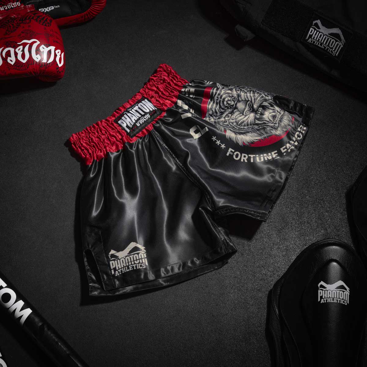 Die neuen Phantom Muay Thai Shorts. Überragende Qualität, Passform und Tragekomfort machen diese Thaishorts zur ersten Wahl für Training und Wettkampf. Im klassichen Muay Thai Stil mit hohem Bund, weit geschnittenen Beinen und glänzendem Material. Ideal für alle Kampfsportler und speziell Thaiboxer. Hier im beliebten Tiger Unit Look.