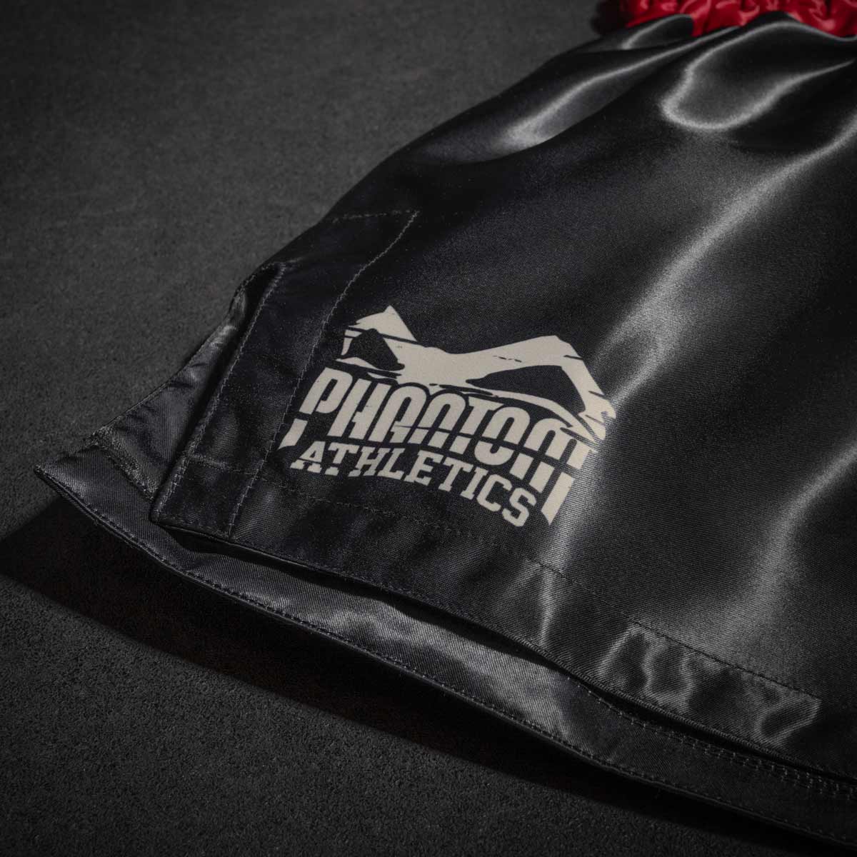 Die Phantom Muay Thai Shorts in schwarz. Oldschool Satin Stoff und unserem beliebten Tiger Unit Design verleiht dir original Thailand Feeling. In gewohnter Phantom Athletics Qualität. Ideal für dein Thaibox Training und den Wettkampf.