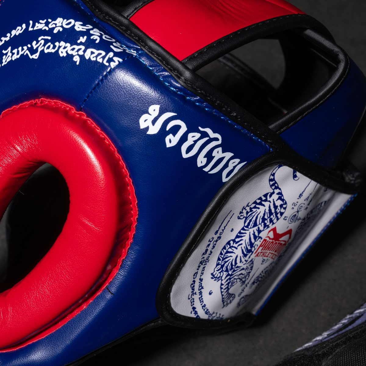 Phantom Muay Thai Kopfschutz für Thaiboxen und MMA Sparring, Wettkampf und Training. Im traditionellen Sak Yant Design und der Farbe Blau/Rot.