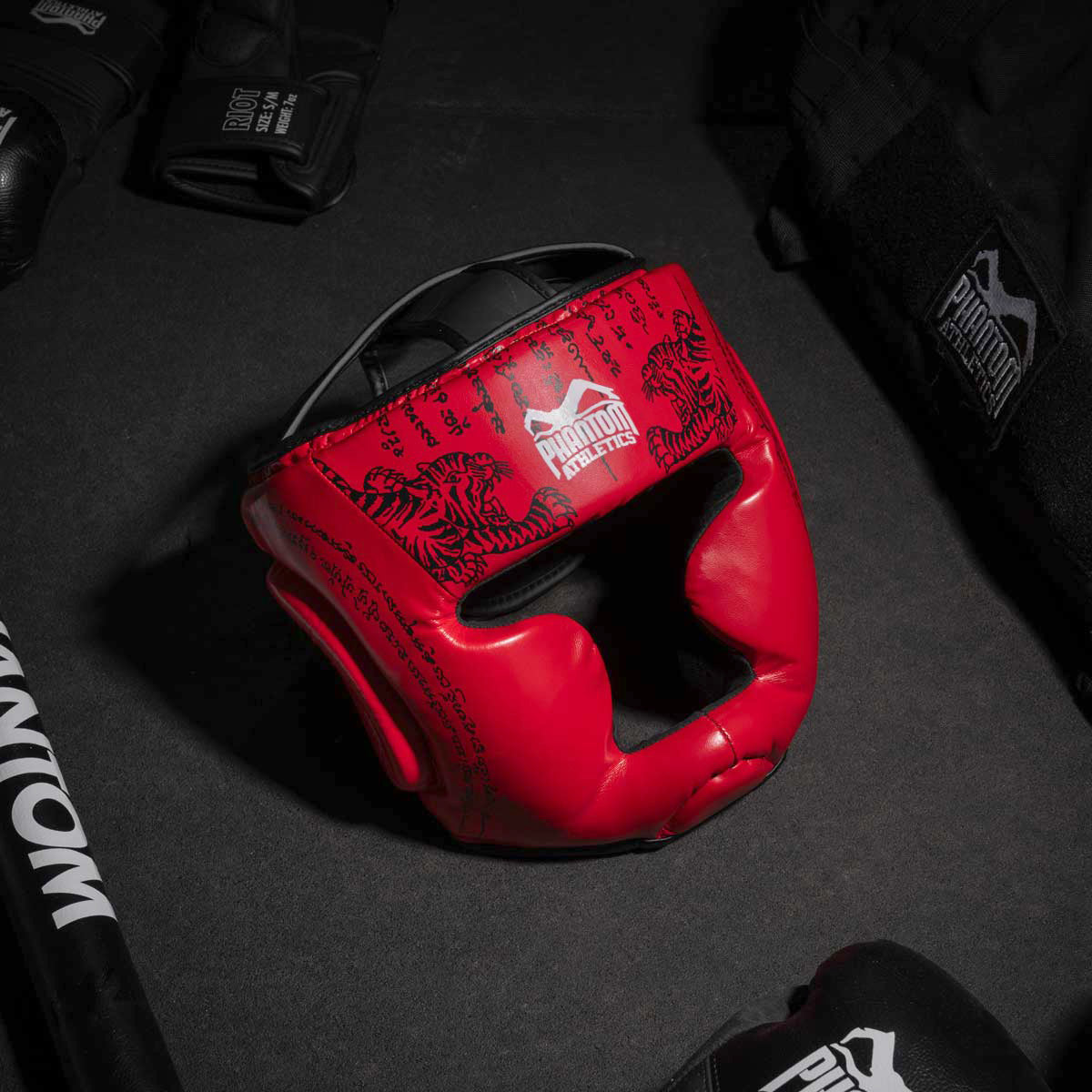 Phantom Muay Thai Kopfschutz für Thaiboxen und MMA Sparring, Wettkampf und Training. Im traditionellen Sak Yant Design und der Farbe Blau/Rot.