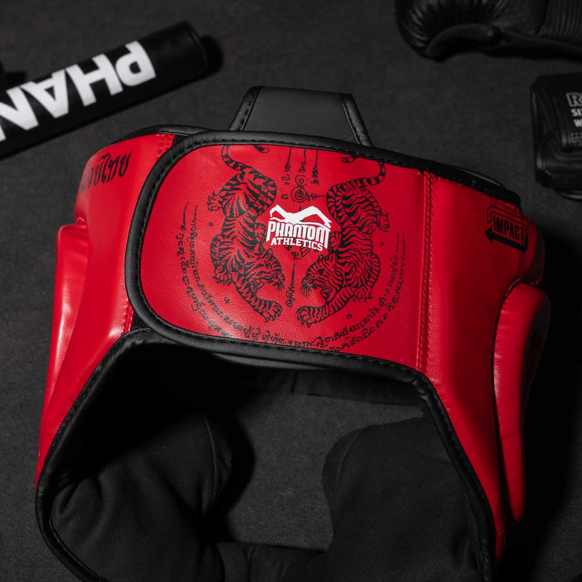 Phantom Muay Thai Kopfschutz für Thaiboxen und MMA Sparring, Wettkampf und Training. Im traditionellen Sak Yant Design und der Farbe Blau/Rot.