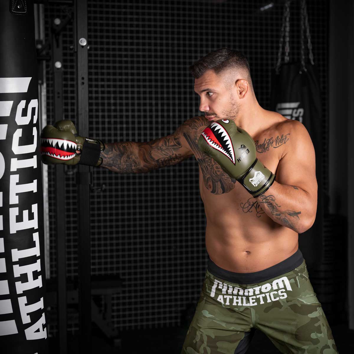 UFC Fighter Aleks Rakic beim Sandsacktraining mit den Phantom Fight Squad Boxhandschuhen in Army grün.