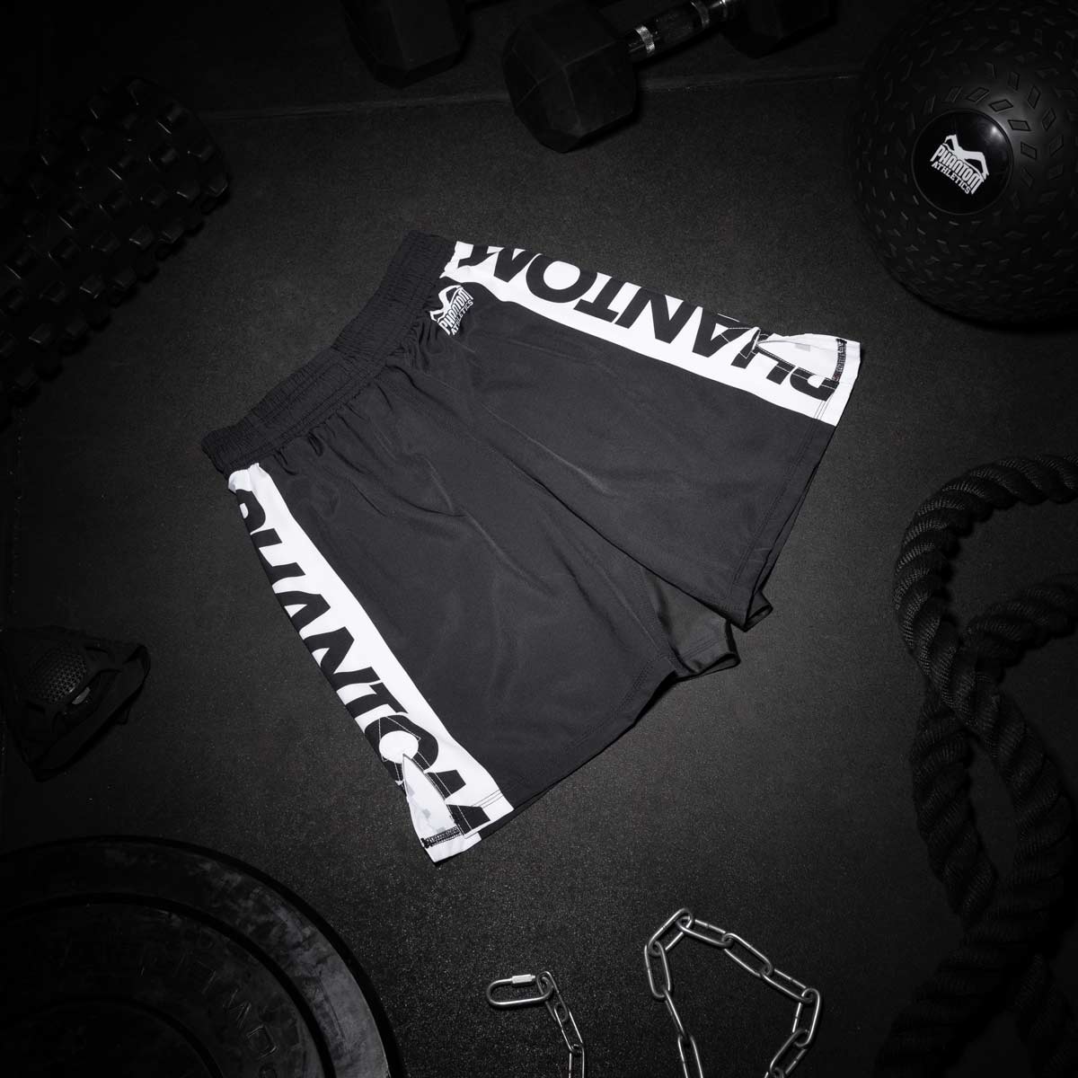 Die Phantom APEX MMA Fightshorts in Schwarz am Gymboden.